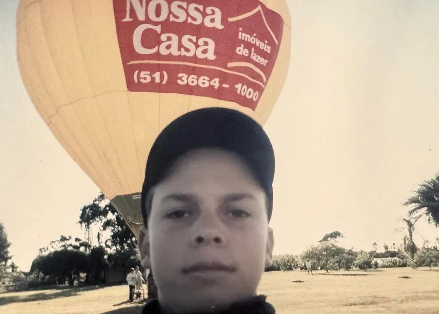 João ainda criança ao lado do balão Nossa Casa, o mesmo modelo com que seria campeão brasileiro em 2024