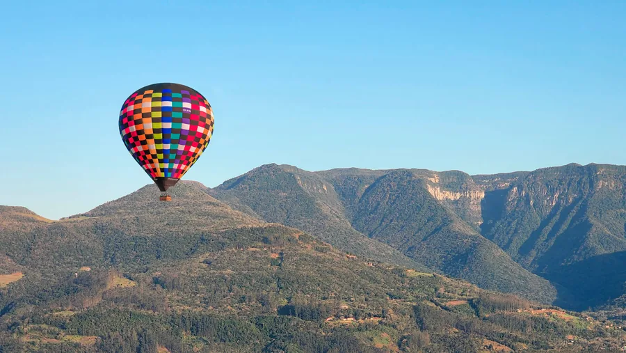 Balão colorido voando diante do paredão dos cânions da Serra Geral